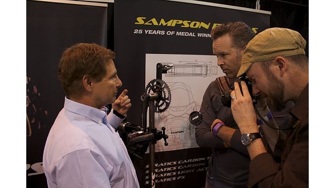 Eric Sampson explains his adjustable pedal to two bike fitters from the Boulder Center for Sports Medicine. 