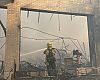 A firefighter hoses down Steve's Bike Shop. Steve Salinas photo. 