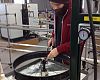 A master wheelbuilder uses a pneumatic tool to place nipples in a fat-bike rim too wide to be accommodated by a Holland wheel-building machine.